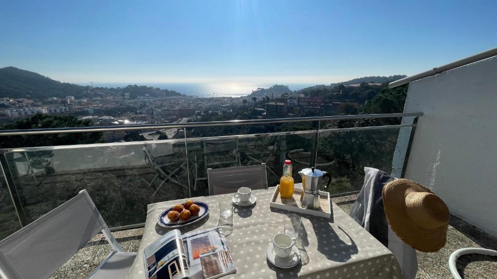 a table with a plate of food on top of a balcony at Villa Mediterraneo in Tossa de Mar