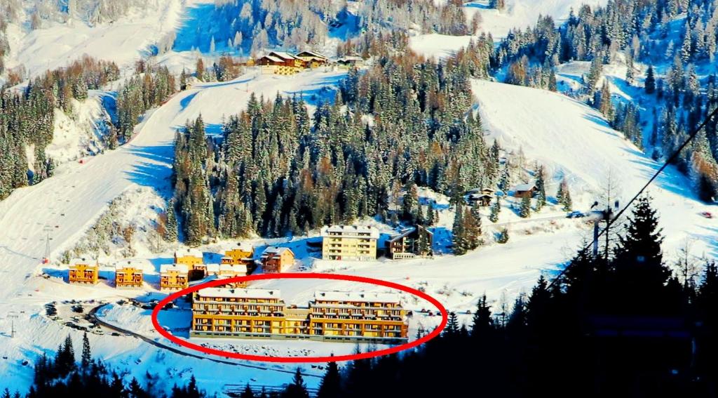 un edificio en medio de una montaña nevada en Appartements Nassfeld LUX en Sonnenalpe Nassfeld