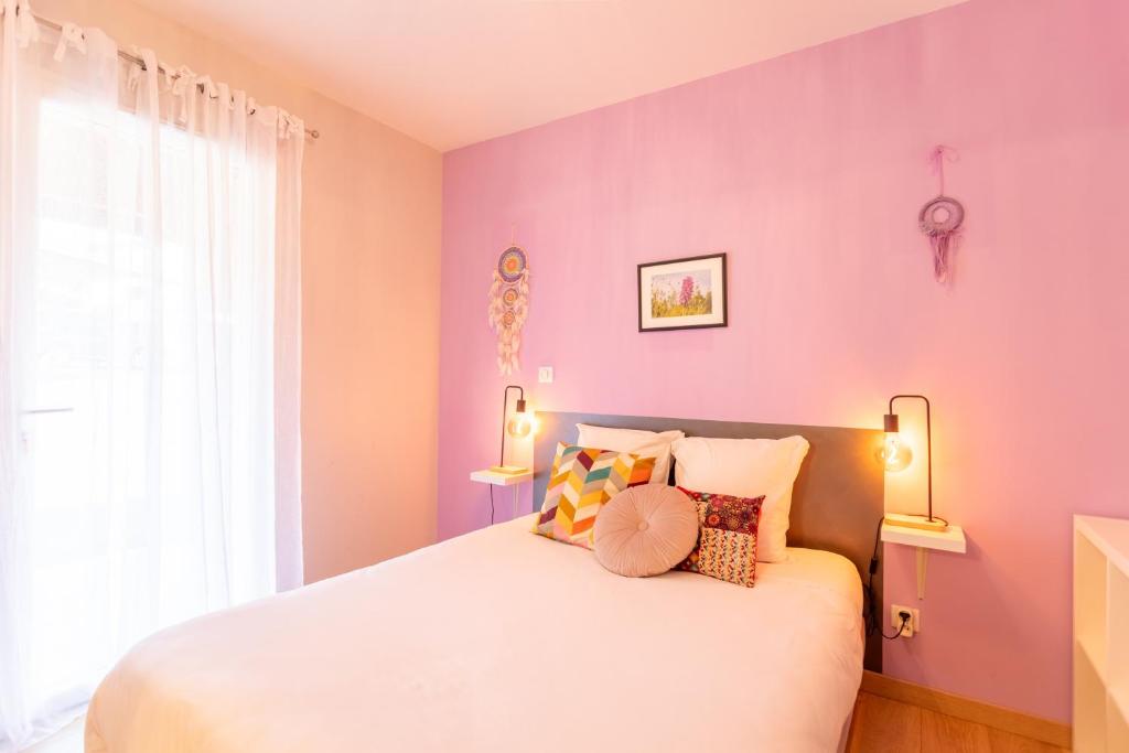 a bedroom with purple walls and a bed with pillows at Chambre - Orchis in Aroue