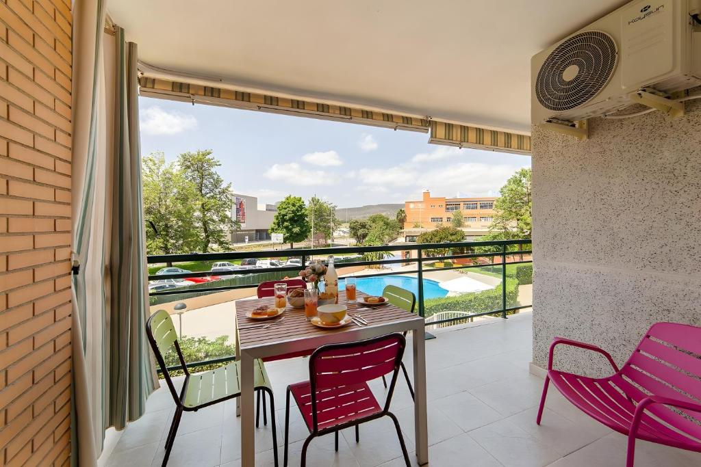 a balcony with a table and chairs and a view of a pool at Calma Mar in Los Mártires