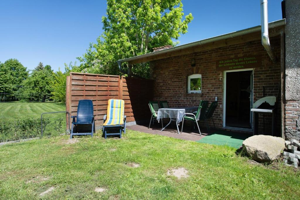 eine Terrasse mit Stühlen und einem Tisch im Garten in der Unterkunft Julenhof in Loitz