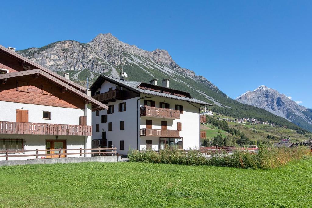 a white building with a mountain in the background at Cima de' Piazzi Apartment 1 in Valdidentro