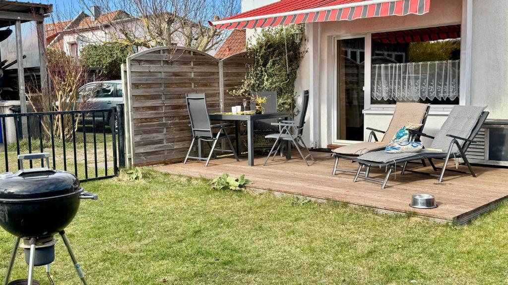 a patio with chairs and a grill in a yard at Haus Usedom in Kröslin