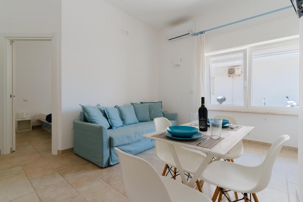 a living room with a blue couch and a table at Casa Anastasia in Otranto