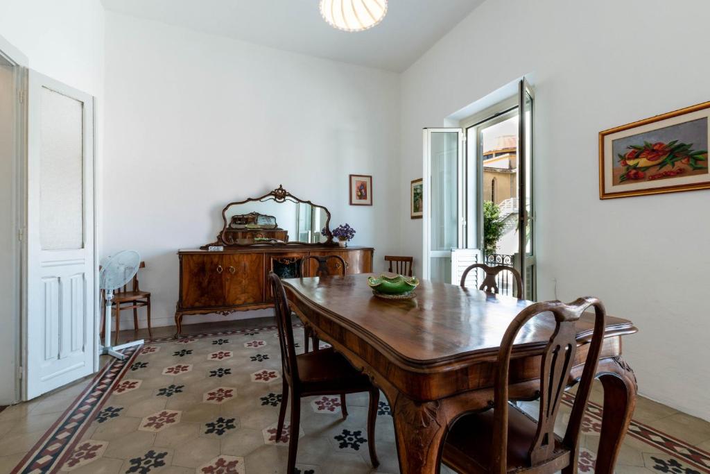 a dining room with a wooden table and chairs at Casa Damiano 1935 in Villasimius