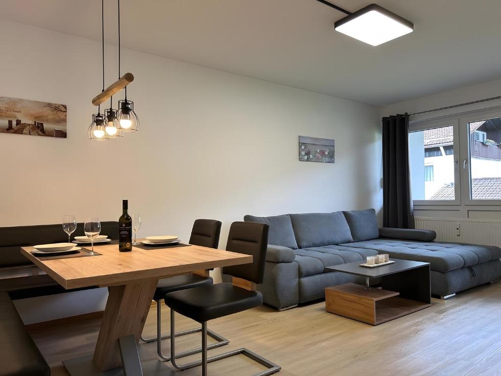 a living room with a blue couch and a table at Fewo A6 mit Sauna und Fitnessraum in Oberaudorf