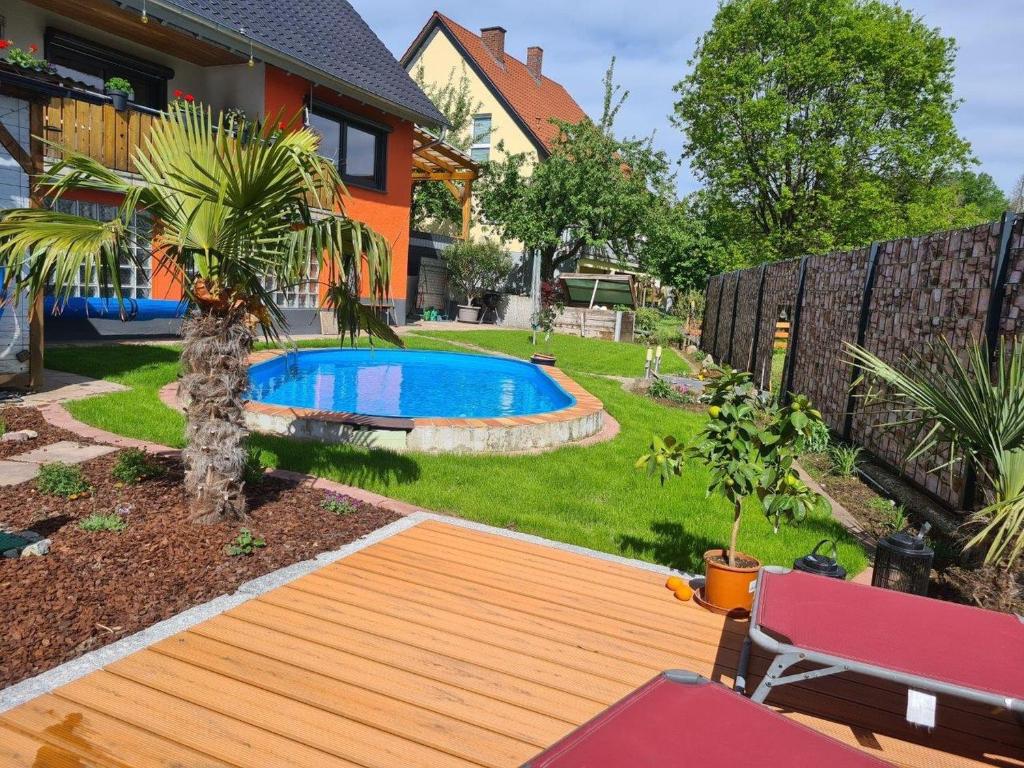 a backyard with a wooden deck and a swimming pool at Ferienwohnung Rimbach in Rimbach