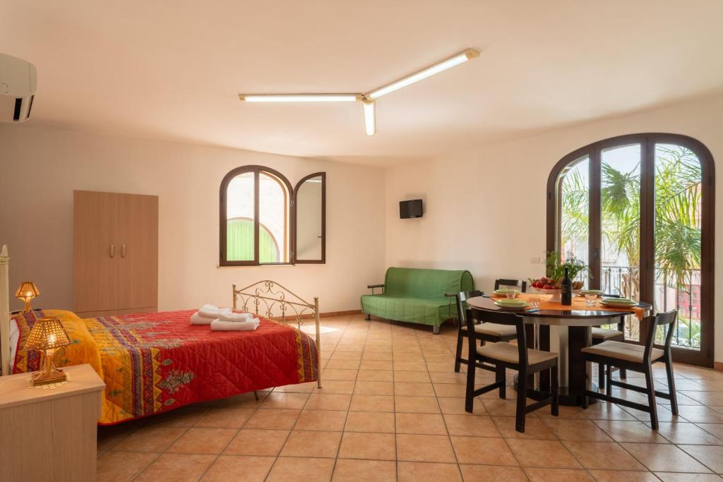 a bedroom with a bed and a table and a couch at Monolocale nel centro di Racale in Racale