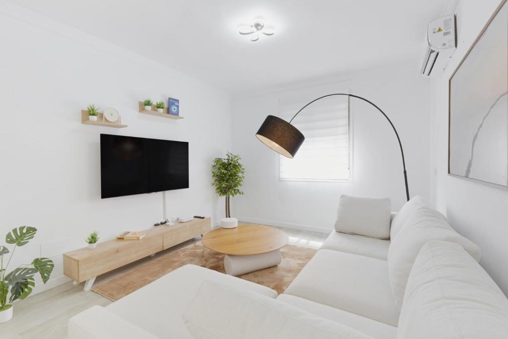 a white living room with a white couch and a table at Casa Pablo City Center in Fuengirola