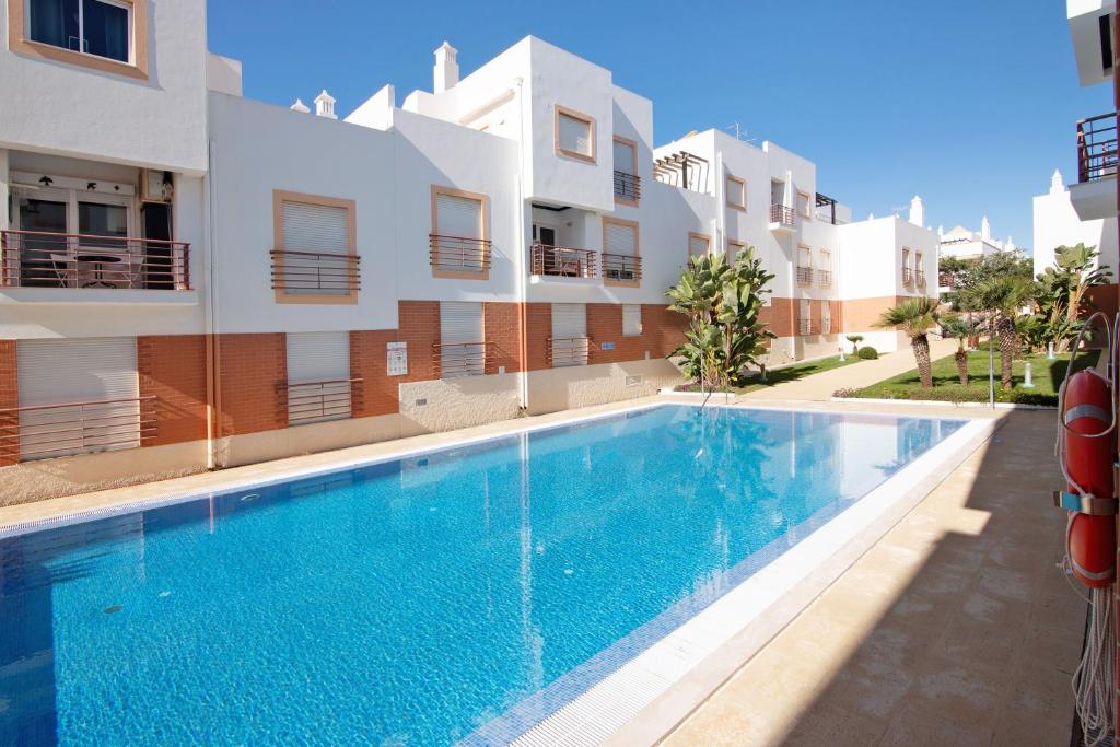 a swimming pool in front of a building at Almadrava House in Tavira