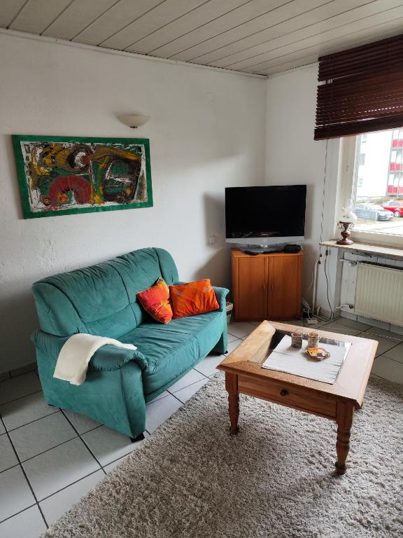 a living room with a green couch and a coffee table at Ferienunterkunft Göhlich in Maintal