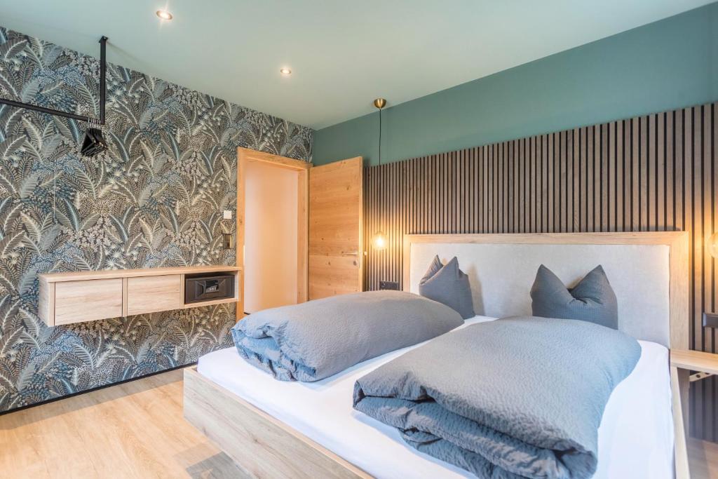 a bedroom with a large white bed with blue pillows at Luisalle Top 3 in Auffach
