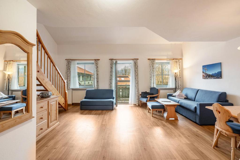 a living room with a blue couch and chairs at Fewo Brünnstein - Nr 46 Pool, Sauna in Oberaudorf
