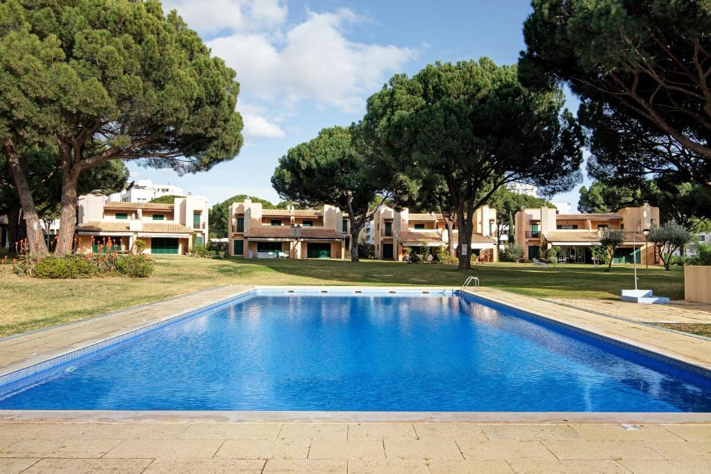 a swimming pool in front of a villa at Vilamoura Tenis 58 in Quarteira