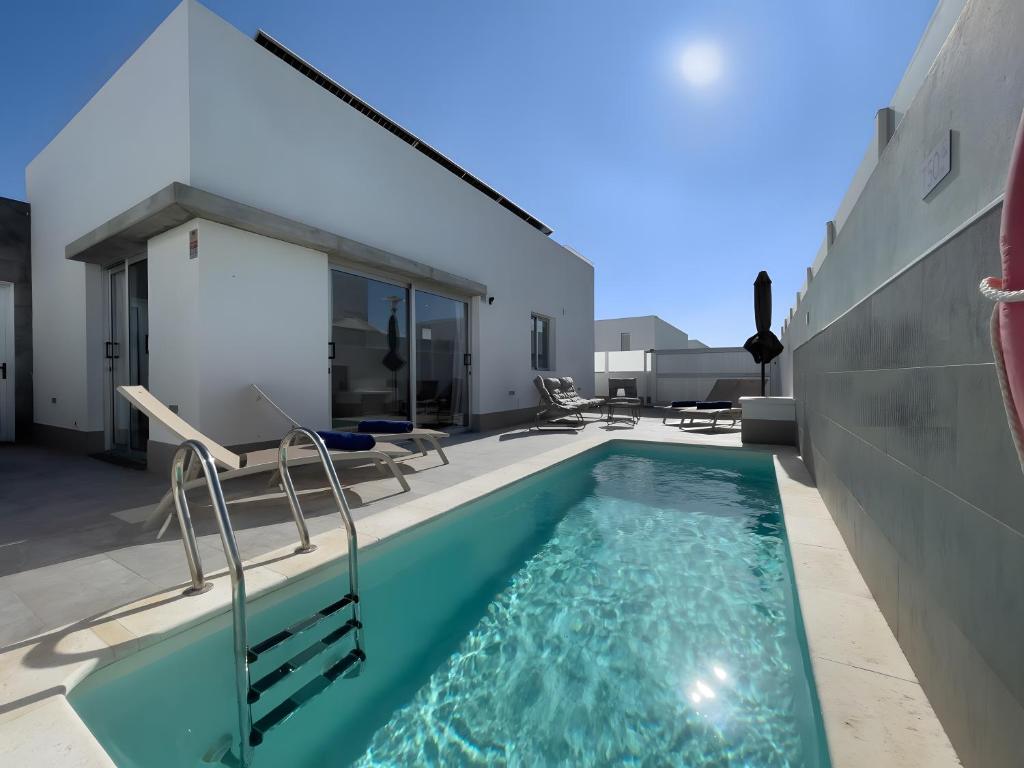 a swimming pool in the backyard of a house at Villa Lychee in Playa Blanca