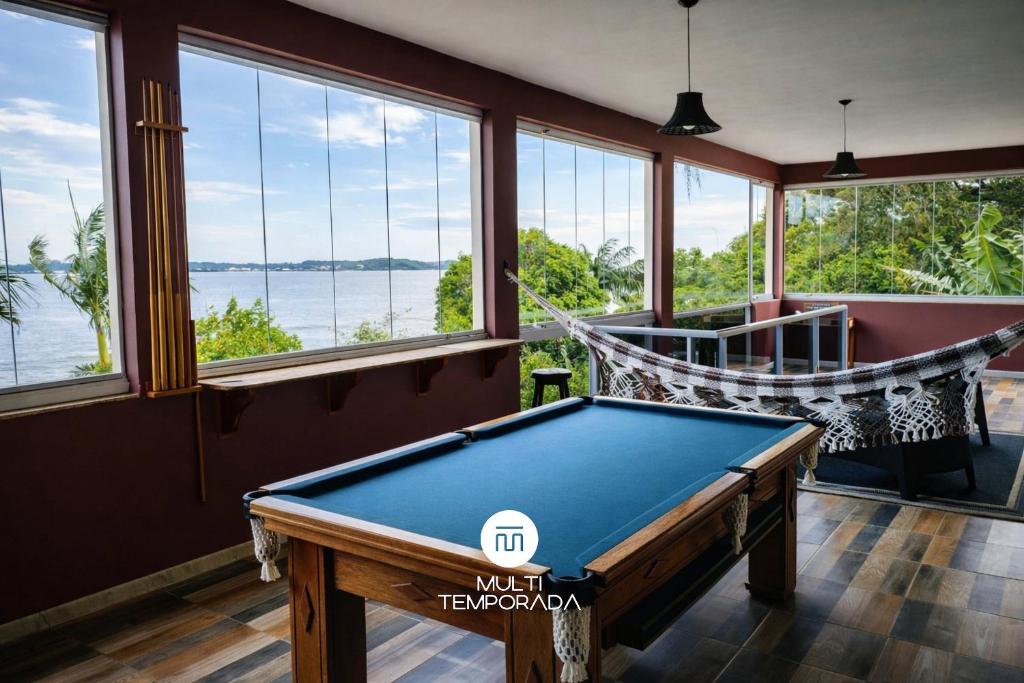 a room with a pool table and a hammock at Casa na Lagoa - Imaruí/SC in Imaruí
