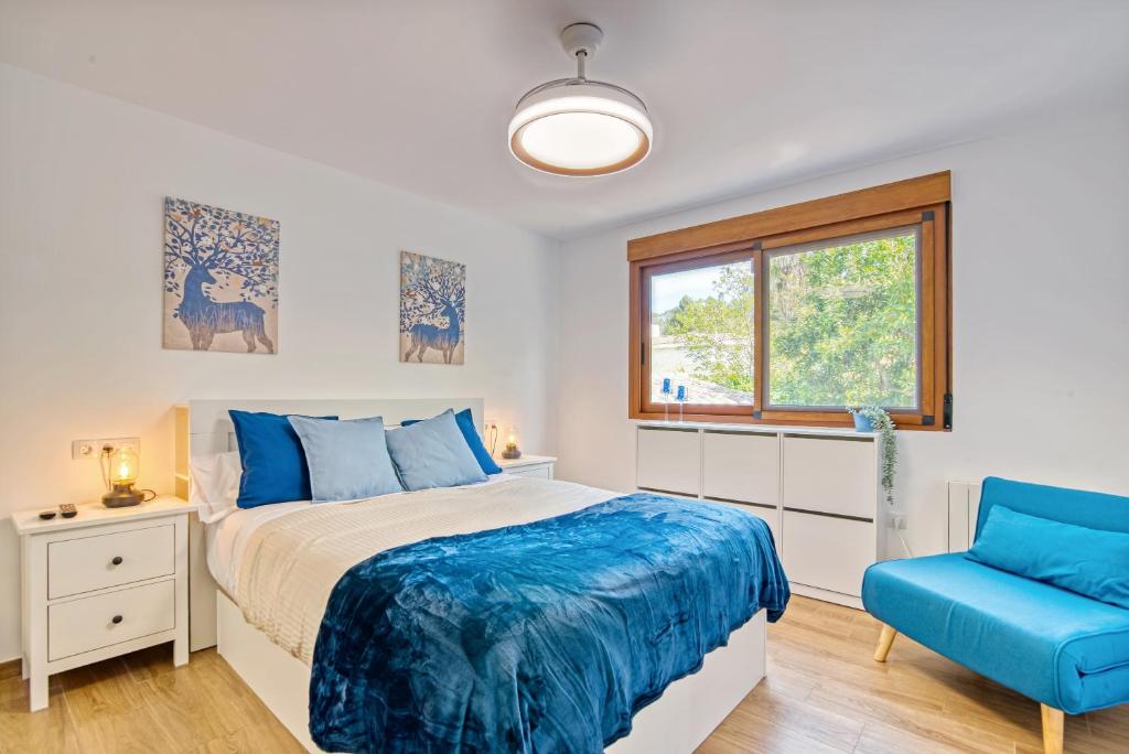 a bedroom with a bed and a blue chair at Violeta Grande in Macastre