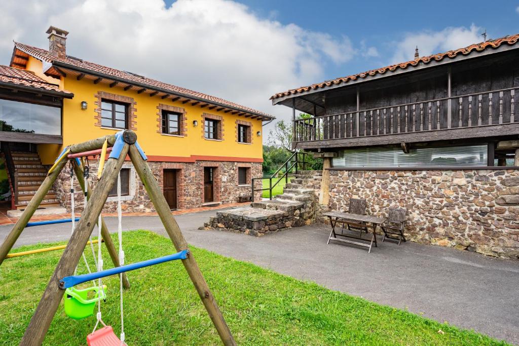 a playground in a yard next to a building at Pedregal in Gijón