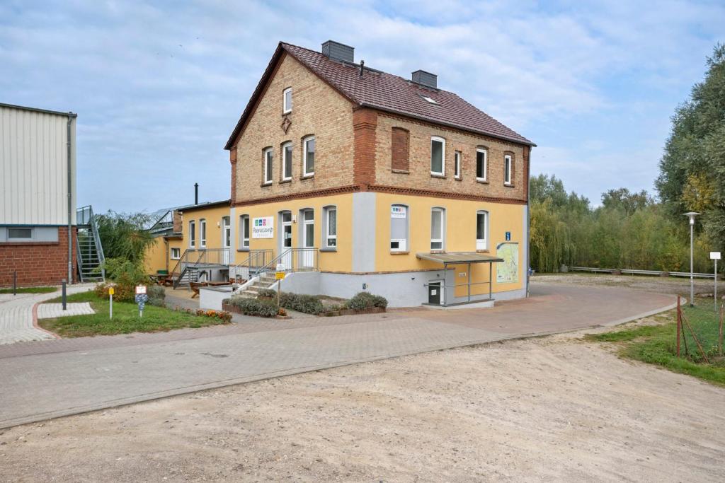 a large brick building on a dirt road at Peenecamp Neukalen, Campingplatz in Neukalen