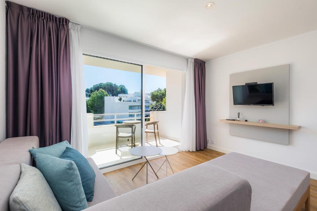 a living room with a couch and a large window at Apartament Massanet 2c in Canyamel
