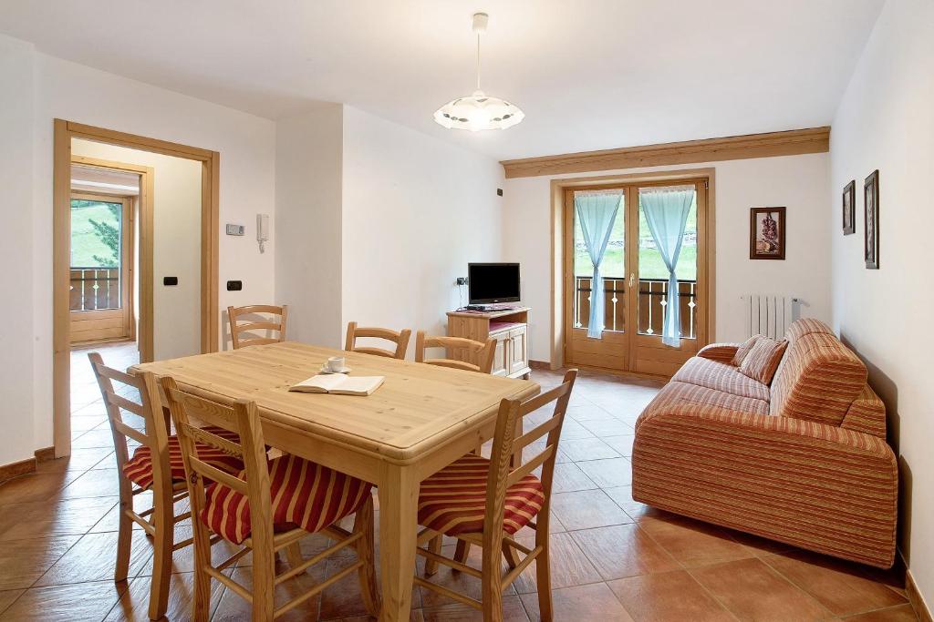a living room with a wooden table and a couch at Casa Michela Bilocale in Valfurva