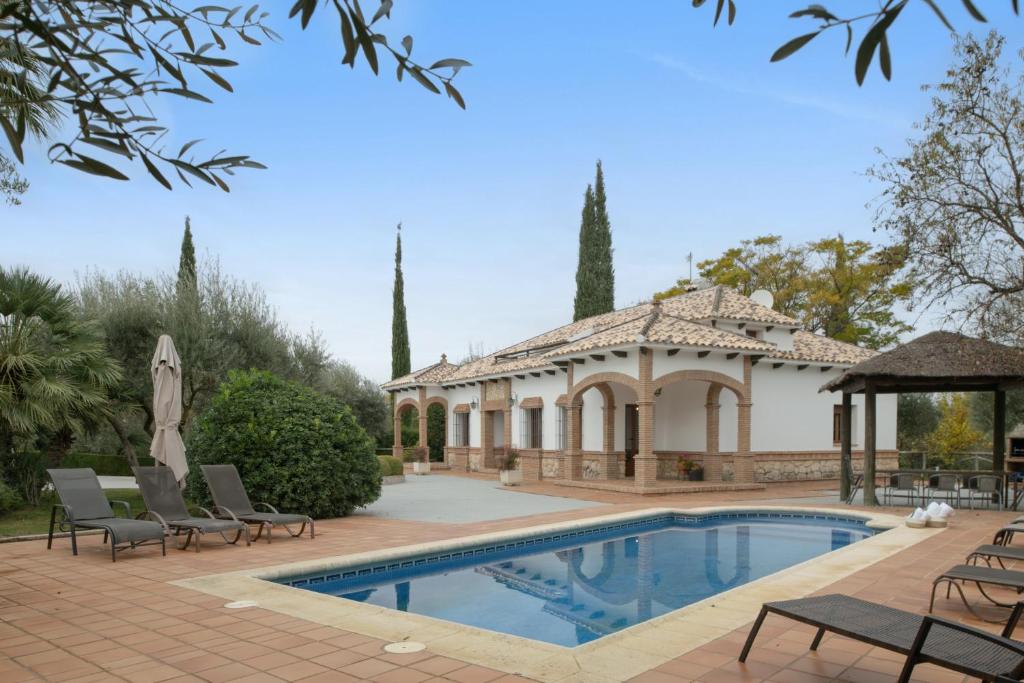 a house with a swimming pool and a gazebo at Villa los mellizos in Arriate