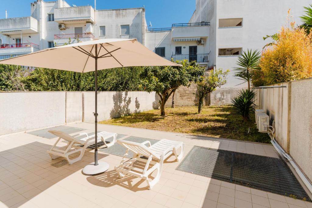 a patio with a table and two chairs and an umbrella at Casa vacanze Elettra in centro in Otranto