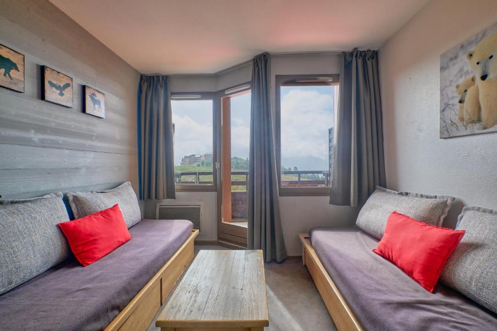 a room with two couches and a table with red pillows at appartement duplex in LʼHuez