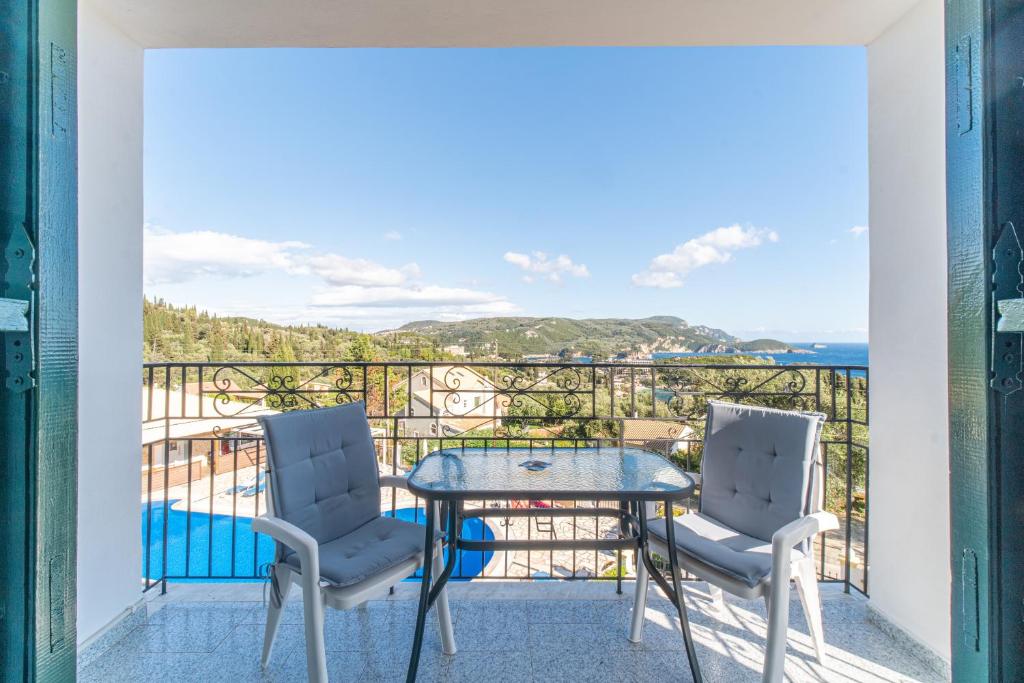 a balcony with a table and two chairs at Captain Spiros Studios in Paleokastritsa