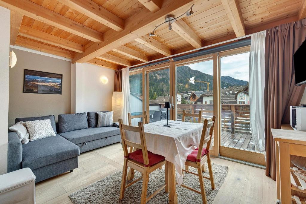 a living room with a table and a couch at Ciasa Irene App Mansarde in La Villa