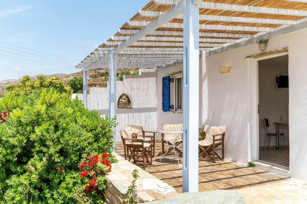 a white house with a wooden pergola at Anemologio 302 Tinos in Agios Ioannis