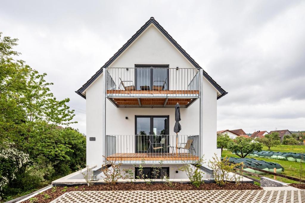 a white house with a deck and a balcony at Fewo Parkside S5 - 8Min Legoland in Günzburg