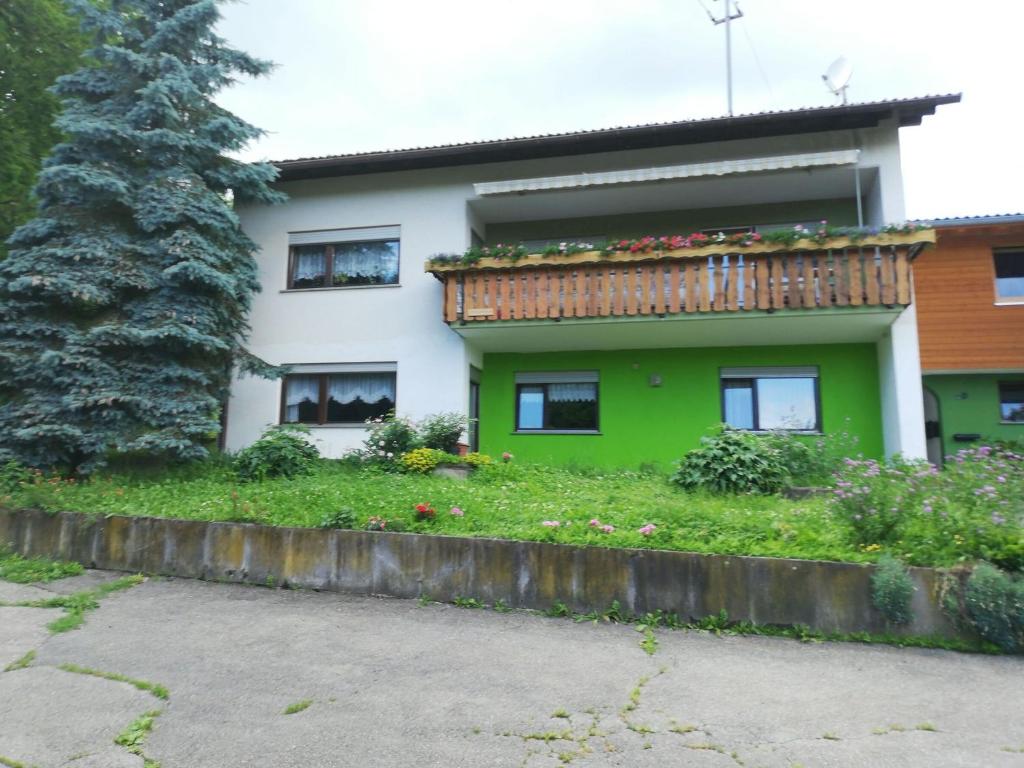 a green and white house with a balcony at Ferienwohnung Josefa Ganter 80qm in Ühlingen-Birkendorf