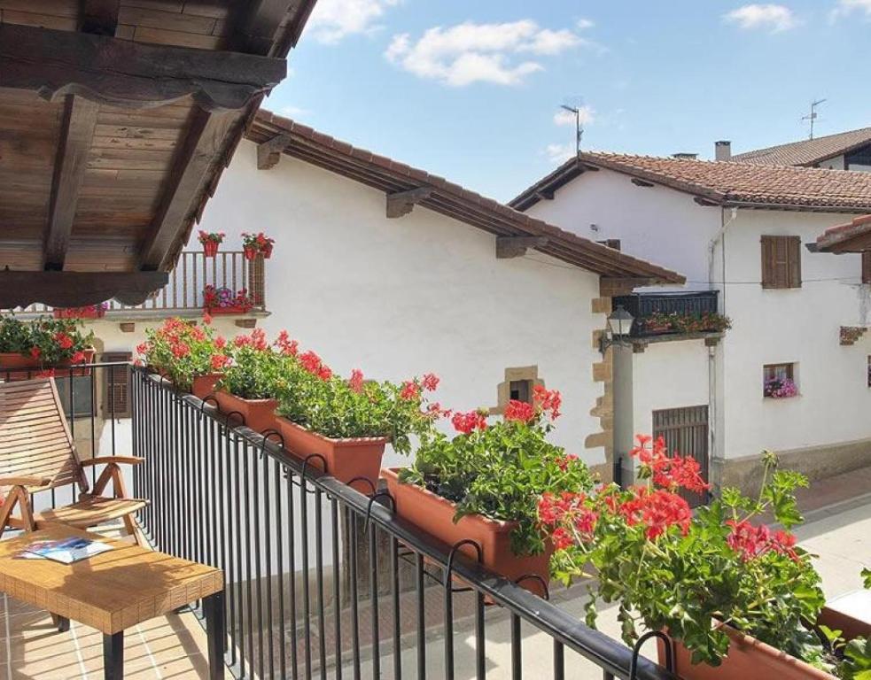 a balcony with flowers and plants on a building at Apartamento ll in Iráizoz