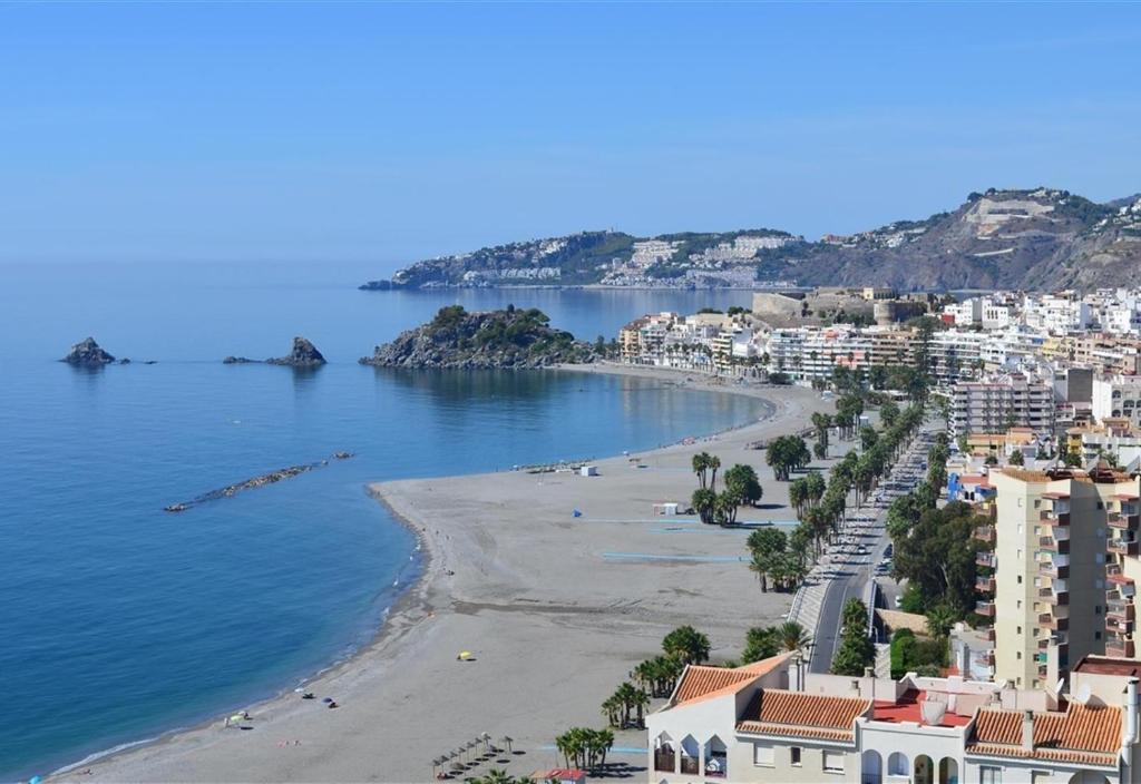 a view of a beach with buildings and the water at Townhouse Almunecar Old Town in Almuñécar