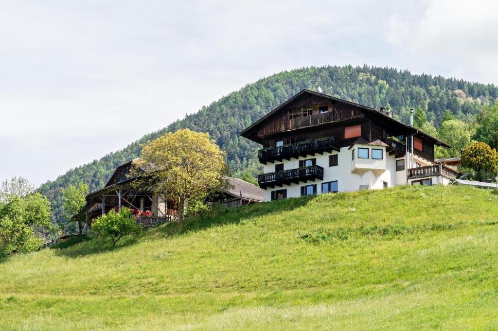 a house on top of a hill on a green field at Gatscherhof Apt Abendrot in Luson