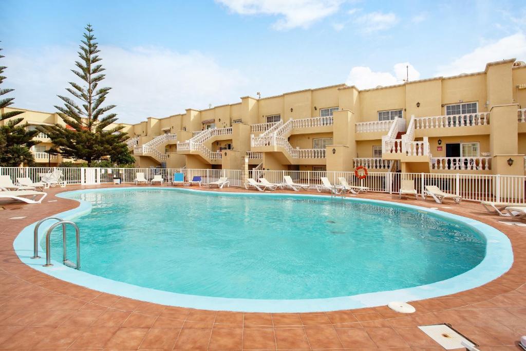 a large swimming pool in front of a hotel at Casa Yeray in Caleta De Fuste