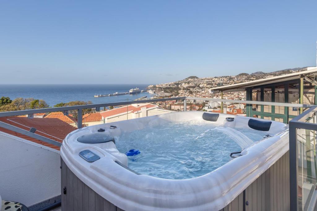 a hot tub on a balcony with a view of the ocean at Sissi Lanço Sea View 7 in Funchal