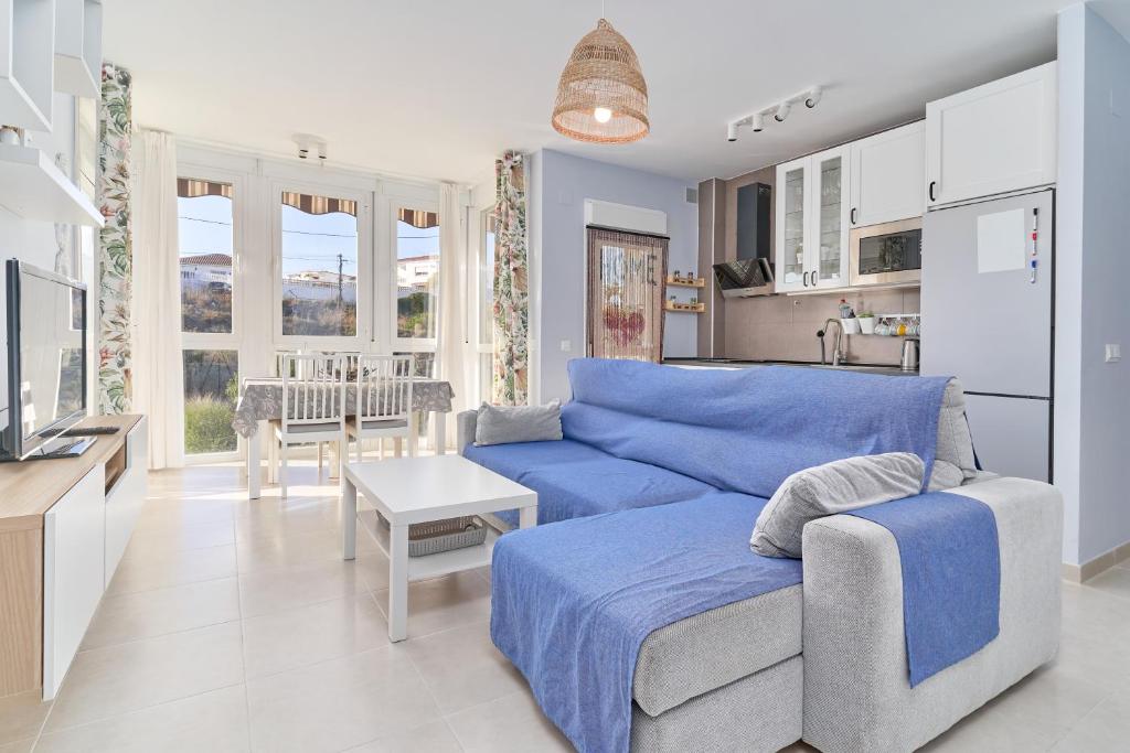 a living room with a blue couch and a kitchen at Recreo 10 in Torrox