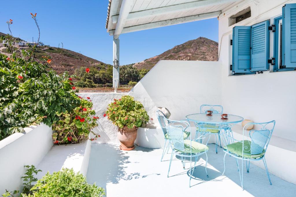 a patio with a table and chairs and flowers at Beachfront Lampis Dolphin 4 in Skala