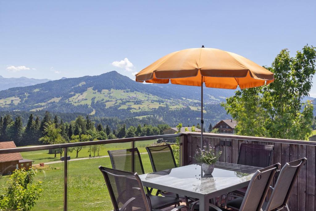 a table and chairs with an umbrella on a balcony at Ferienwohnung Böhler in Doren