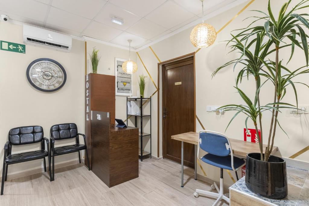 an office with a desk and chairs and a clock at 7A Hostal in Torrevieja