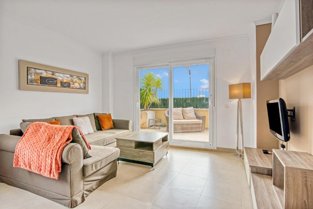 a living room with a couch and a tv at Amanda in Jávea