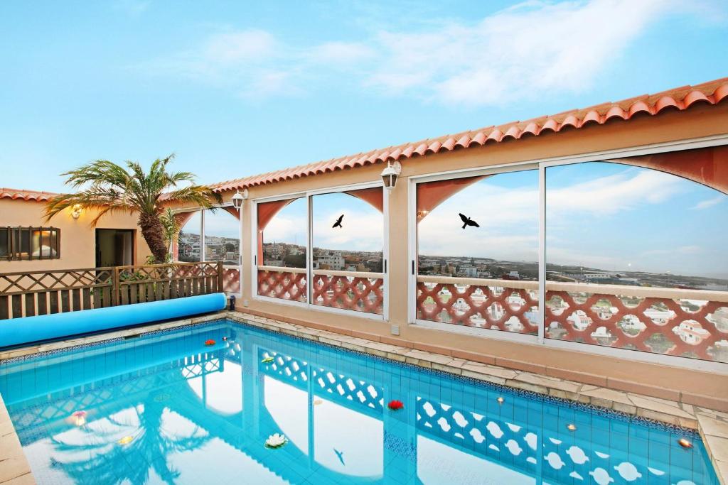 a swimming pool on the balcony of a house with birds in the sky at Apartament Studio Petite Paradise in Las Lagunas