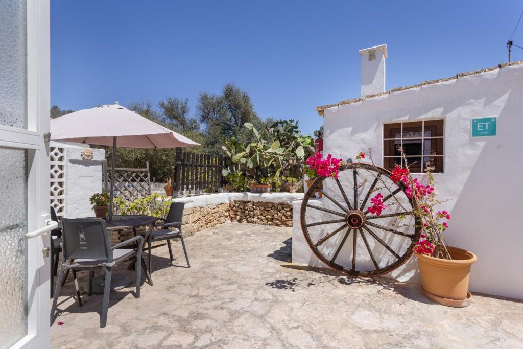 a patio with a table and chairs and a wheel at Can Vital 2 in Illes Balears