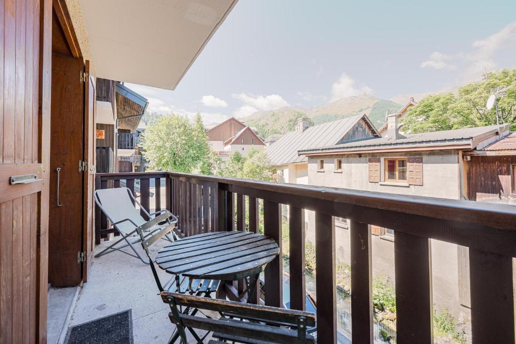 a porch with a table and a chair on a balcony at Résidence Les Bergers 71 in Valloire