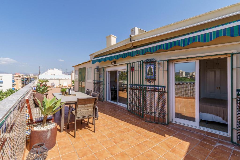 a patio with a table and chairs on a balcony at Penthouse Victoria in Fuengirola