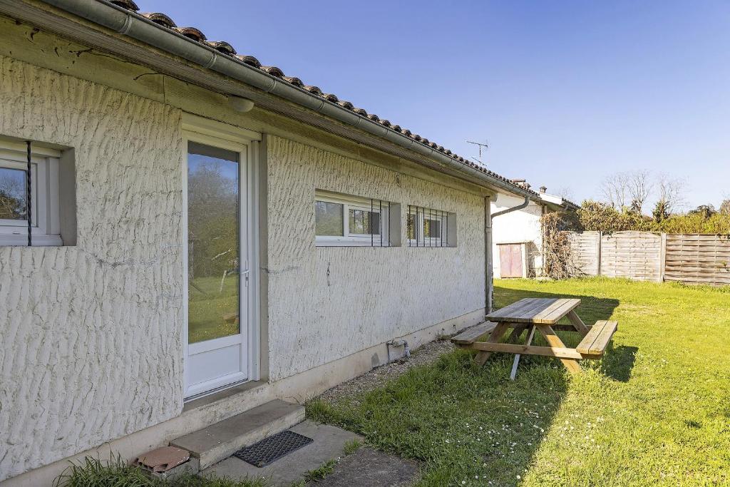 a picnic table next to a building with a window at Gîte de Mirabel Château Saint Ahon in Blanquefort