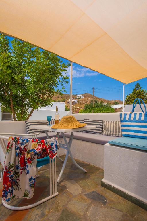 a table and chairs under an umbrella on a patio at Pico Bello Patmos 12 in Patmos