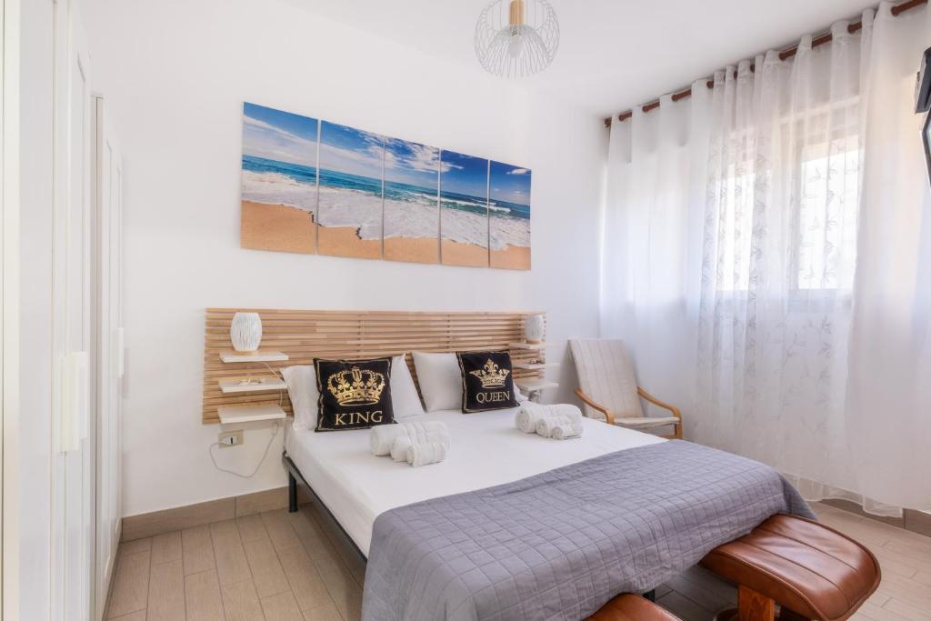 a bedroom with a bed and a painting on the wall at Rossini 14 Centro e Mare a Piedi in Porto Cesareo